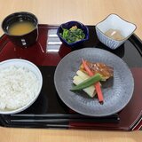 スーパーコート高石羽衣の昼食プライムメニュー。黒と朱色のお膳に載った、太刀魚の蒲焼、蓮根饅頭、菜の花の和え物、ご飯、お味噌汁の和食セット。