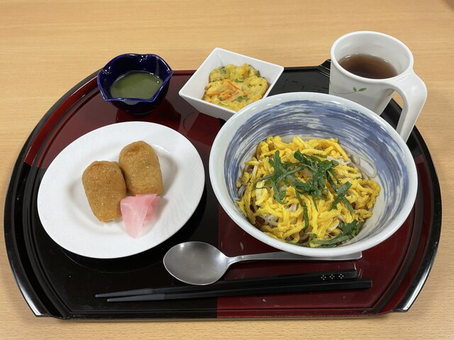 alt="スーパーコート高石羽衣の「プライムメニュー」：いなり寿司、冷や麦（錦糸玉子・大葉トッピング）、かき揚げ、抹茶水羊羹、お茶が並んだ食膳の様子。"