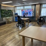 スポットクーラーを稼働させた2階共用ホールでテレビを観て快適に過ごす入居者様の様子