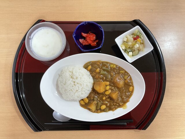 alt="スーパーコート高石羽衣で提供された『快調献立』。白いお皿に盛られたお豆たっぷりのカレーライス、カラフルな夏野菜サラダ、フルーツヨーグルト、赤い福神漬けがお盆に並ぶ様子"
