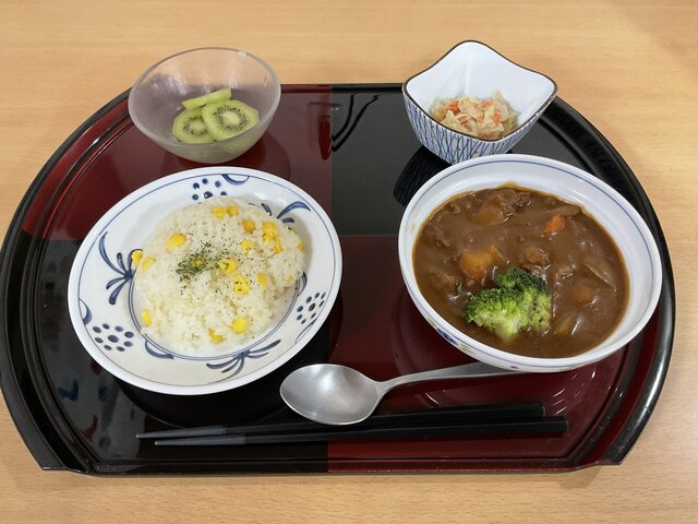 alt="スーパーコート高石羽衣の夕食プライムメニュー。コーン入りバターライス、具だくさんビーフシチュー、キャベツの胡麻ドレサラダ、キウイフルーツ"