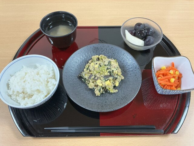 alt="スーパーコート高石羽衣で提供された薬膳定食。トレイ中央に豚ひき肉と黒きくらげの炒め物、左下に白いご飯、右下に人参サラダ、左上に大根と生姜のスープ、右上にブドウとナシの季節のフルーツ、手前にお箸が置かれている。"