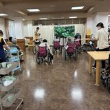 スーパーコート高石羽衣のカラオケ大会の様子。大型モニターの前で歌や映像を楽しみながら、スタッフとともにお茶を飲んで和んでいる風景。
