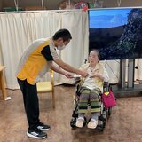 体操キャンペーン表彰式にて、スタッフから表彰状と記念品を受け取るご利用者様の様子
