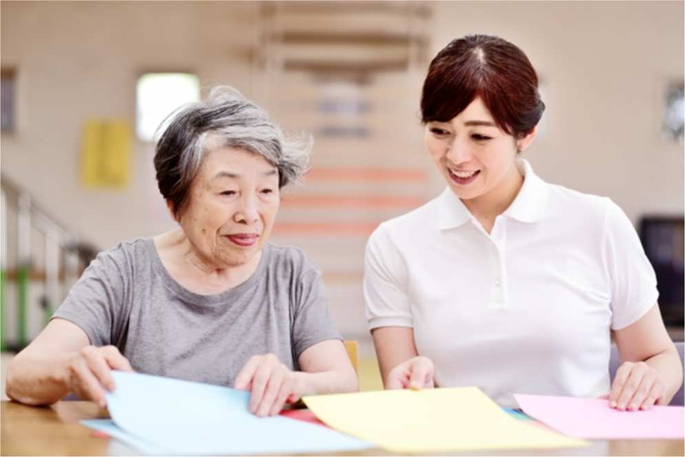 介護スタッフと話す高齢女性