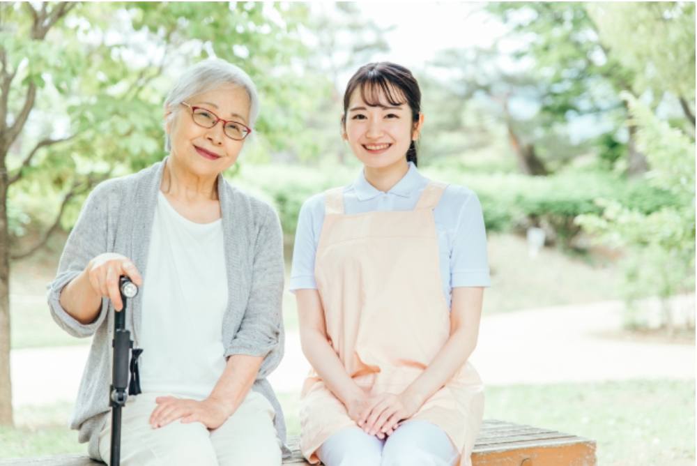 ベンチに座る高齢女性と介護職員