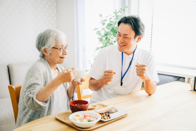 庭で花に水をやる高齢者と介護スタッフ
