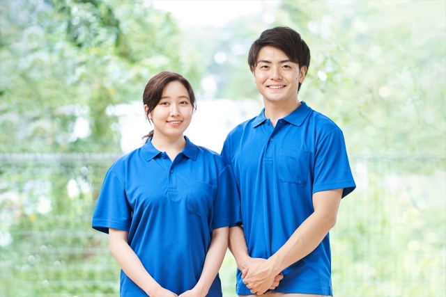 老人ホームの庭で談笑する高齢者とスタッフ