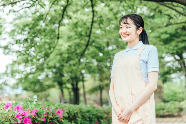 車椅子に乗った高齢女性が花のプランターを手入れしている様子