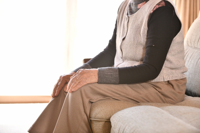 施設の窓から外を眺める高齢の男女