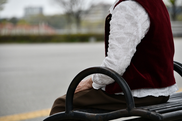 自宅で一人座っている高齢の女性