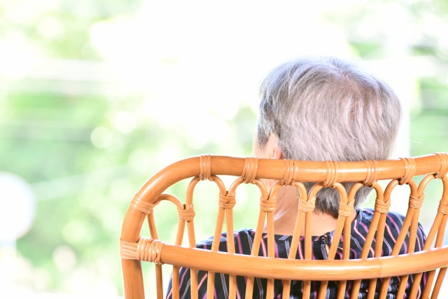 介護スタッフの介助でリハビリをする高齢の女性