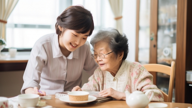 笑顔で話す高齢女性と介護スタッフ